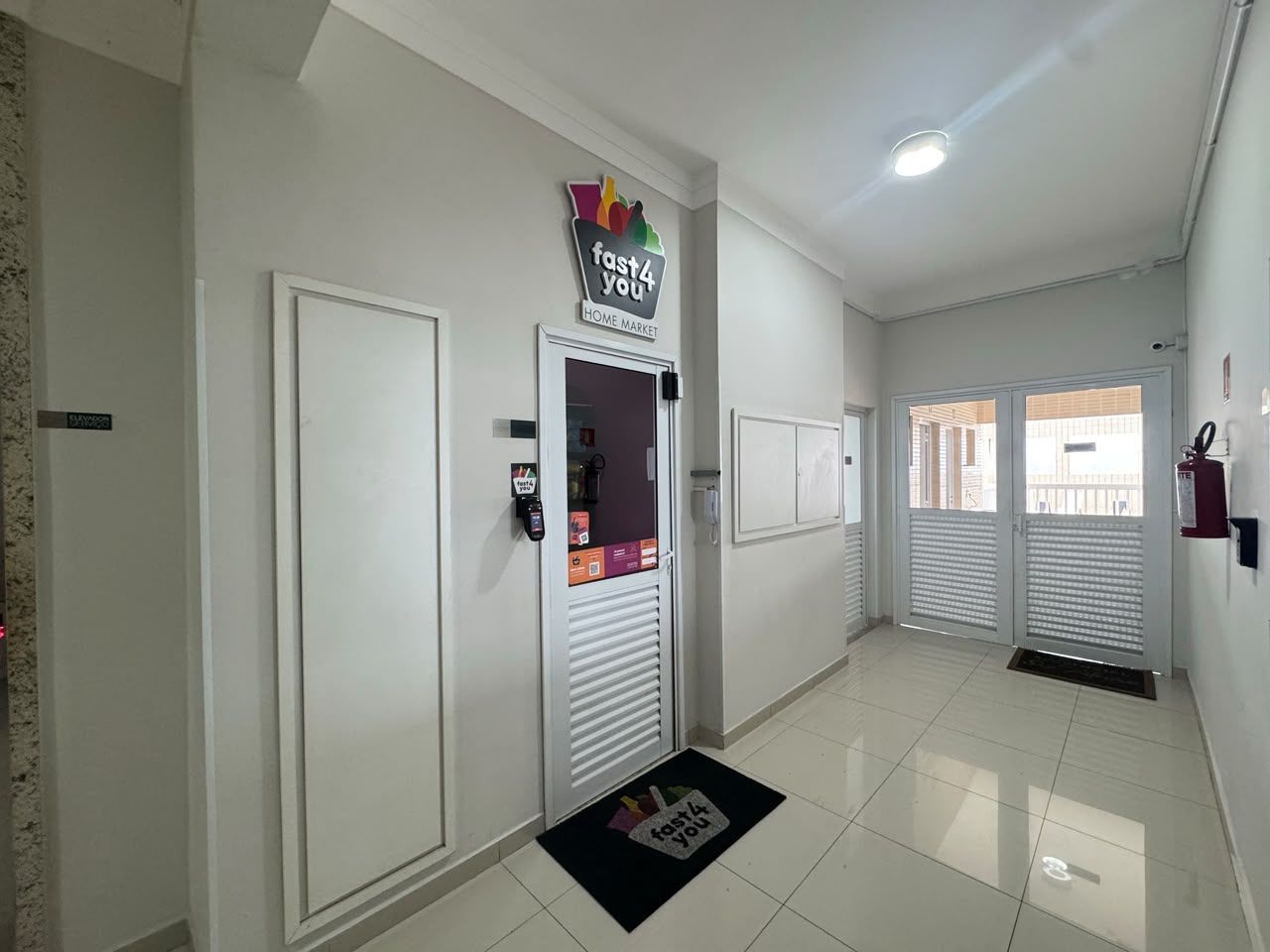 Hall do andar com a porta do mercado 24h Fast4You