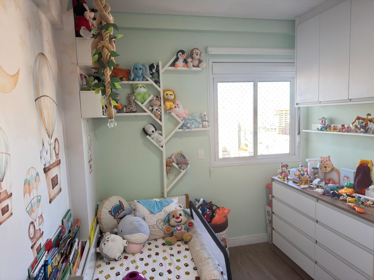 Quarto infantil com janela, cômoda e armários suspensos
